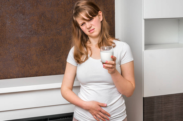 Жінка з проблемою лактози страждає від болю в шлунку
 - Фото, зображення