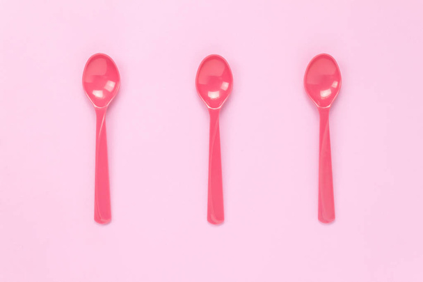 Top view colorful plastic spoon on pink table. - Photo, Image