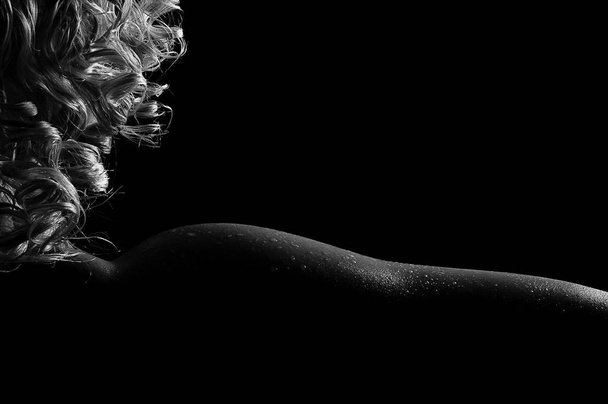 Beautiful sexy kinky blonde female, in oil with drops of water on the body, tender bends of the naked neck, shoulder and forearm, gorgeous in the darkness. Black and white photo. - Photo, Image