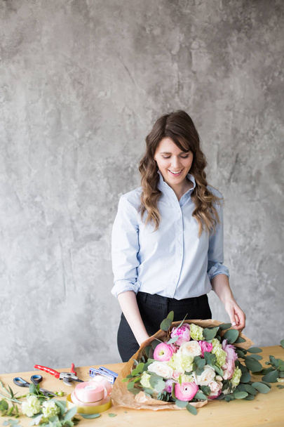 Флорист на роботі: красива молода жінка робить моду сучасним букетом з різних квітів
 - Фото, зображення