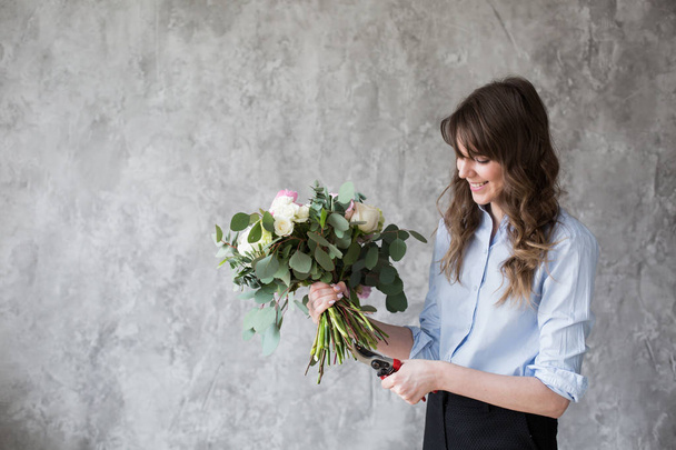 Kukkakauppias töissä: kaunis nuori nainen tekee muoti moderni kukkakimppu eri kukkia
 - Valokuva, kuva