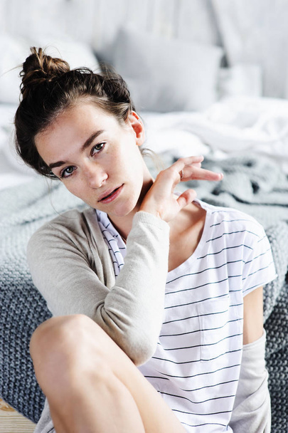 beautiful young feminine sexy woman relaxing in bedroom in lazy weekend morning, wearing casual fashion clothes - Fotoğraf, Görsel