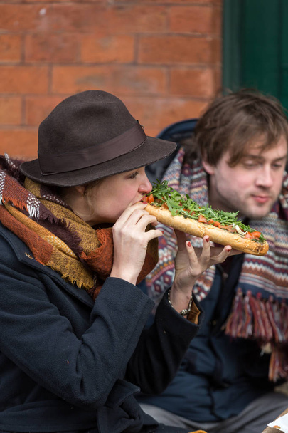 Os jovens comem Zapiekanka - fast-food polonês uma caçarola em Plac Nowy no distrito de Kazimierz, Cracóvia
 - Foto, Imagem