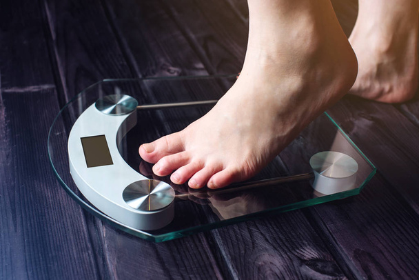 Kobiece nogi stojąc na wagi elektroniczne, do kontroli masy ciała - Zdjęcie, obraz