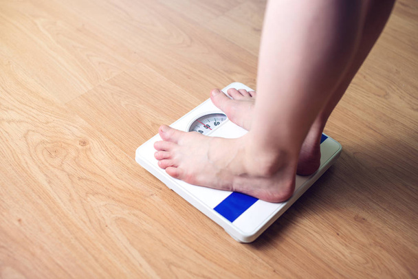 Women's voeten zijn op mechanische weegschaal voor gewichtsbeheersing - Foto, afbeelding