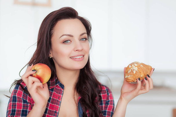 Ernährung. Diätkonzept. Gesunde Ernährung. schöne junge Frau, die zwischen Früchten und Süßigkeiten wählen kann. Gewichtsverlust - Foto, Bild