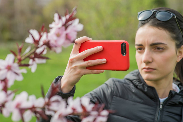 Girl takes pictures of nature and flowers - Foto, immagini