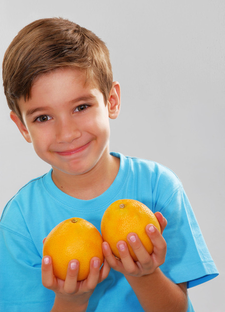 Little kid holding fresh oranges. - Fotó, kép