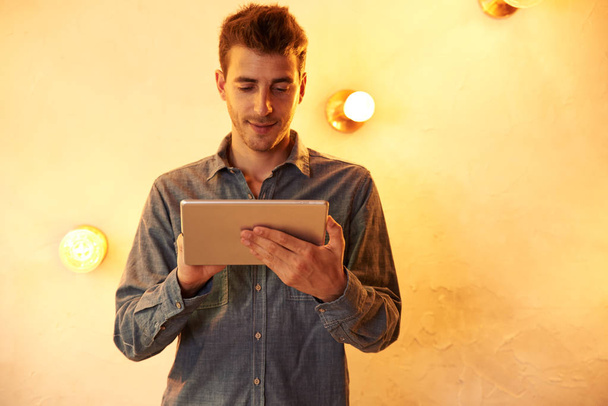 Handsome young man using tablet - 写真・画像