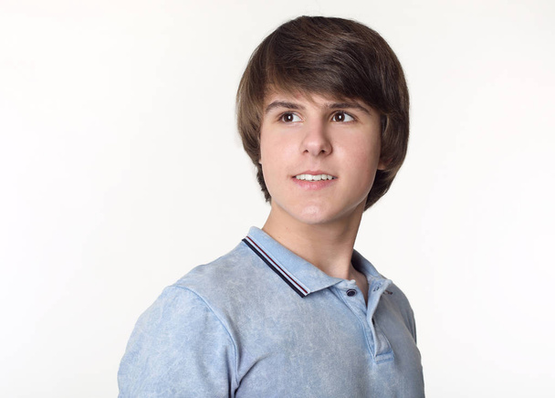 Portrait of young handsome man, teenage boy isolated on studio w - Foto, Bild