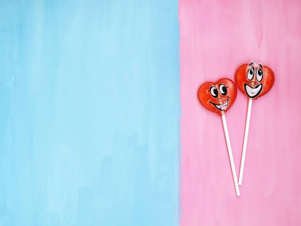 Pembe ve mavi arka plan üzerinde iki lolipop. Aşk kavramı. Sevgililer günü - Fotoğraf, Görsel
