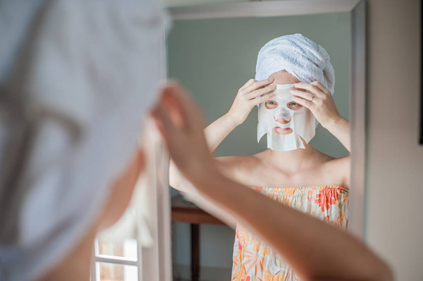  woman doing facial mask sheet - Zdjęcie, obraz