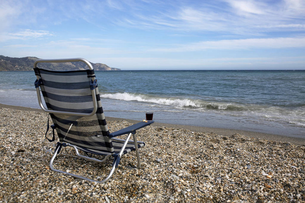 empty sunbed with glass of red wine on the beach - Zdjęcie, obraz