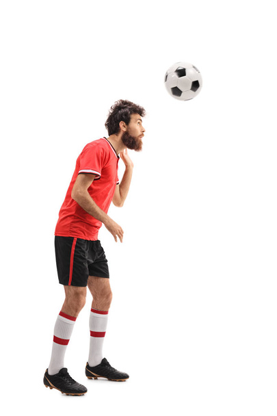 Guy in a red jersey heading a football - Zdjęcie, obraz