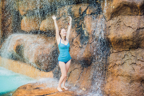 woman relaxing under a waterfall in aquapark - Zdjęcie, obraz