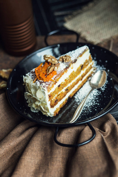 Slice of carrot cake with cream cheese and walnuts. The restaurant or cafe atmosphere. Vintage - Фото, зображення