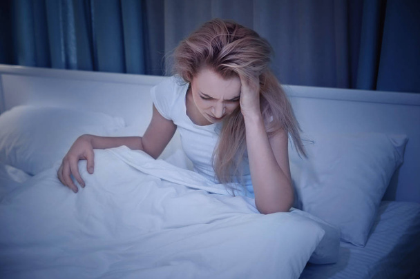 Beautiful young woman suffering from headache while resting in bed at night - Φωτογραφία, εικόνα