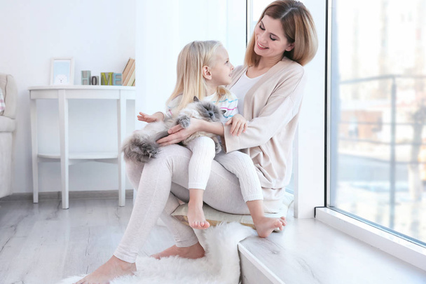 Mother and her daughter with cat  - Foto, Bild