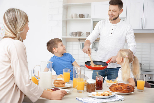 Famille heureuse petit déjeuner sur la cuisine
 - Photo, image