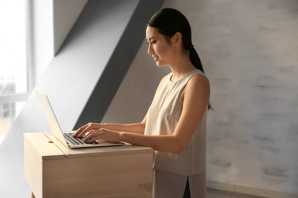 Asian woman typing on laptop  - Valokuva, kuva