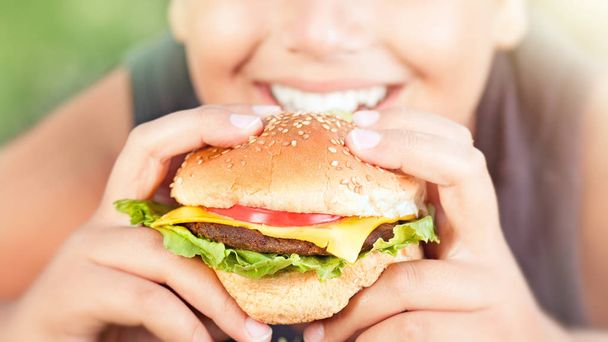 Happy teen boy eating burger - Foto, Imagen