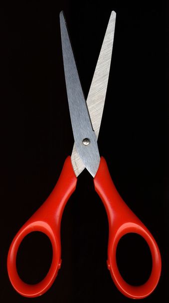 Red scissors against a black background color - Фото, зображення