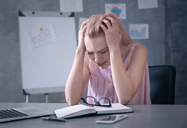 Mulher bonita sofrendo de dor de cabeça enquanto trabalhava no escritório
 - Foto, Imagem