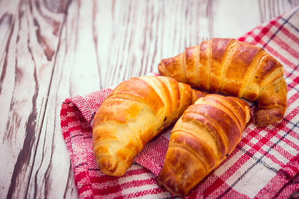 Delicious croissants on a wooden background - Photo, Image