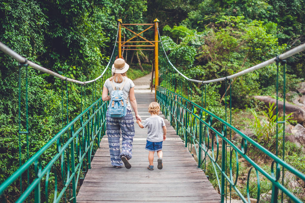 Mother and son are going on a suspension bridge - Фото, зображення