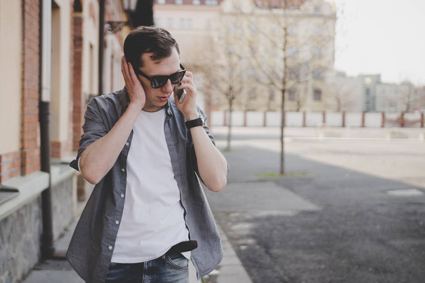 Young hipster man walking on the street and talking on phone - Zdjęcie, obraz