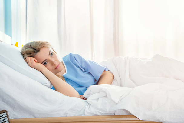 woman lying in hospital bed - 写真・画像