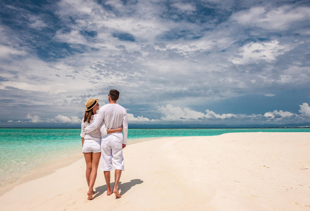Пара в белом, гуляющая по пляжу
 - Фото, изображение