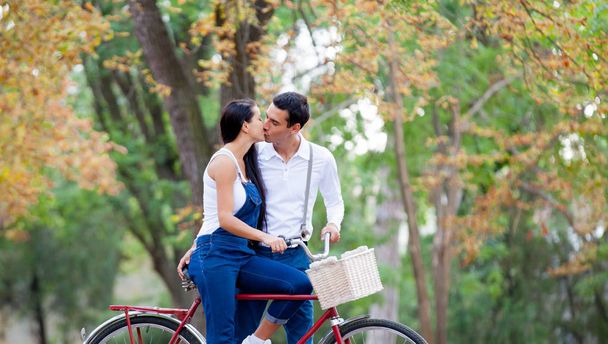 Foto von niedlichen Paar sitzt auf dem Fahrrad und küsst auf dem Wunder - Foto, Bild