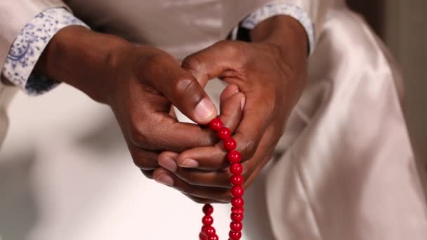 Ένας άνθρωπος προσεύχεται ενώ χρησιμοποιείτε χάντρες - Πλάνα, βίντεο