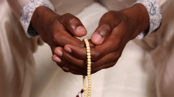 Egy ember imádkozik a rózsafüzért gyöngyök segítségével - Felvétel, videó