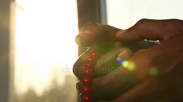 Hands and beads at sunset - Video