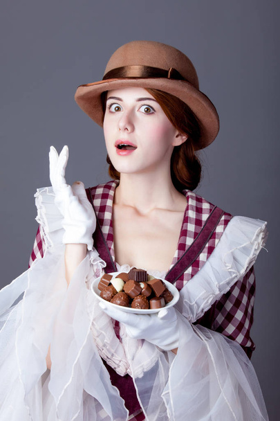 photo of beautiful young woman in vintage dress with plate full  - Photo, Image