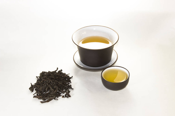 uma dispersão de chá e a xícara chinesa em um fundo branco
 - Foto, Imagem