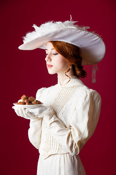 photo of beautiful young woman in vintage dress with plate full  - Foto, imagen