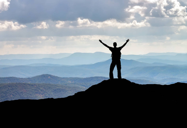 Silhouet van een man op een bergtop. Persoon op de rots.  - Foto, afbeelding