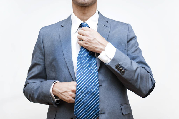 Młody biznesmen dostosowuje jego krawat - Zdjęcie, obraz