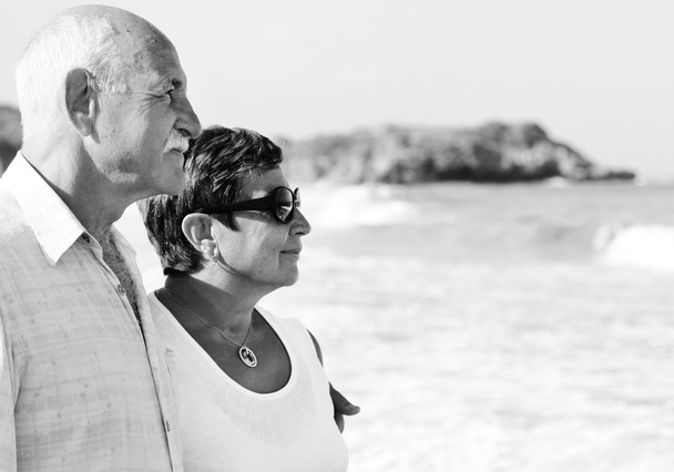 Happy senior couple walking together on a beach - Photo, Image