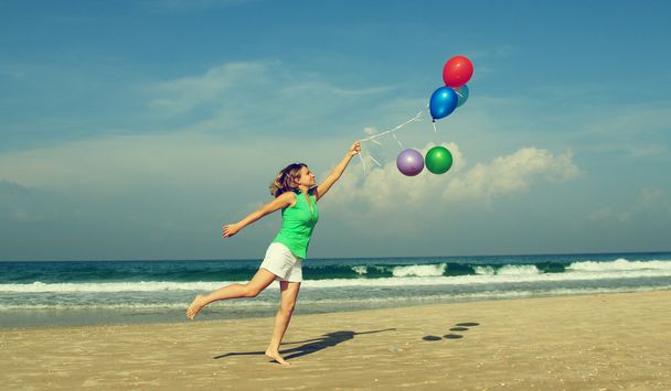 mooi meisje met een ballonnen op het strand. oude stijl kleuren. - Foto, afbeelding