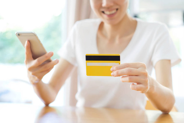 Portrait of a happy woman buying online with a smart phone  - Fotó, kép
