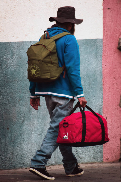 Piros táska és hátizsák szegény ember az utcán. - Fotó, kép
