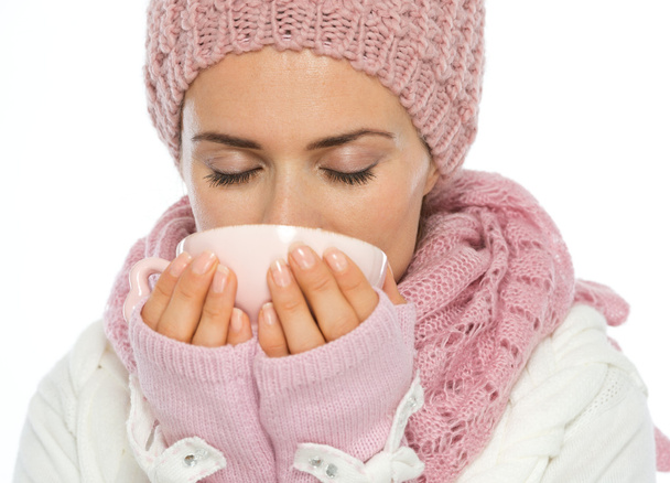 Woman in knit scarf, hat and mittens drinking hot beverage - Foto, imagen