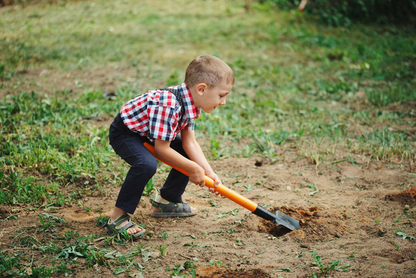 little funny boy with shovel in garden - Foto, Imagem
