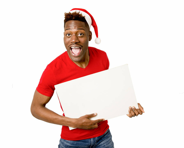 zwarte afro Amerikaanse man in Christmas Santa hat glimlachend gelukkig leeg reclamebord kopie ruimte tonen - Foto, afbeelding
