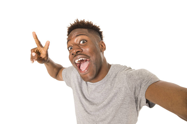 молодий афро-американський чоловік посміхається щасливий, приймаючи селфі-портрет з мобільним телефоном
 - Фото, зображення