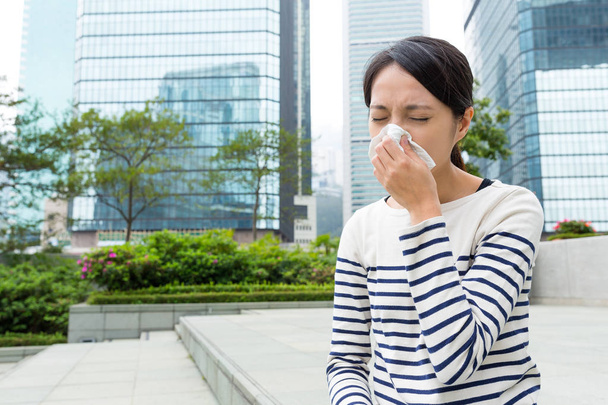 Mujer estornudando al aire libre
 - Foto, imagen